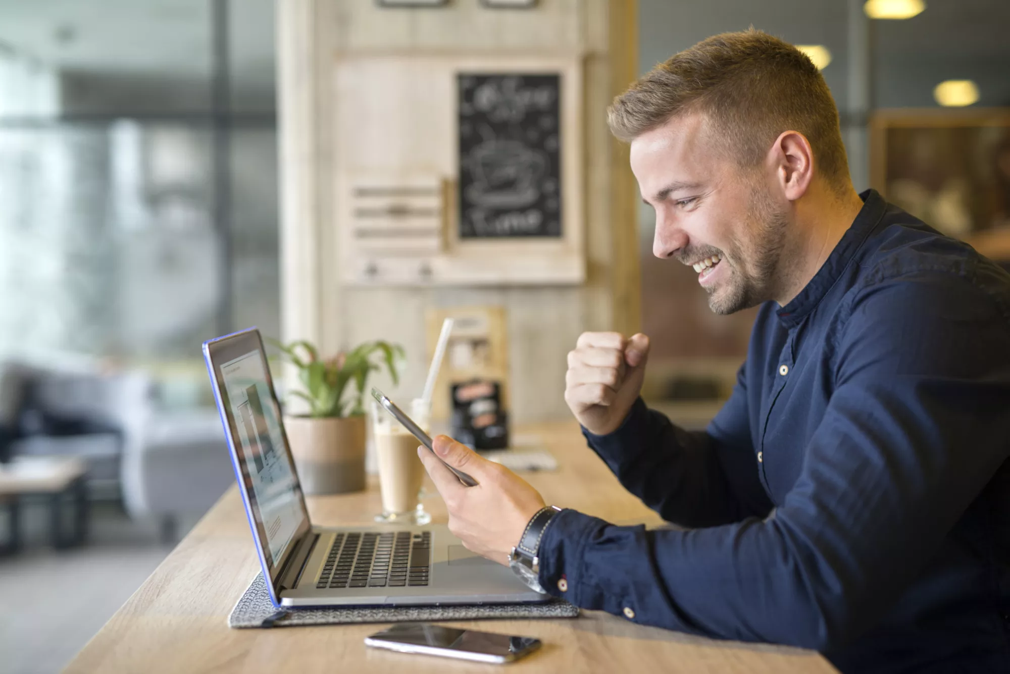 happy-freelancer-with-tablet-and-laptop-computer-in-coffee-shop-scaled.jpg