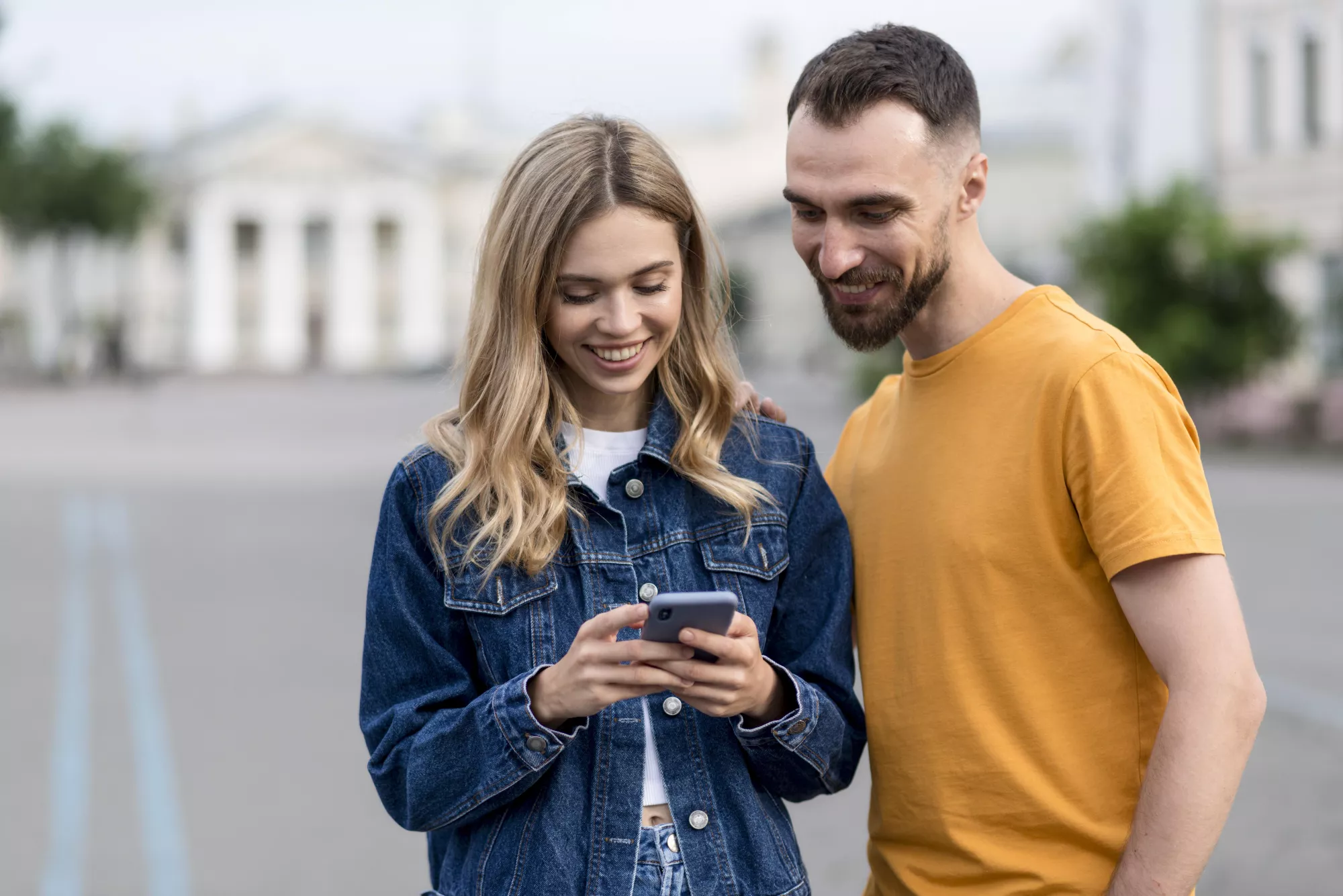 Une femme et un homme regardant l'écran d'un smartphone