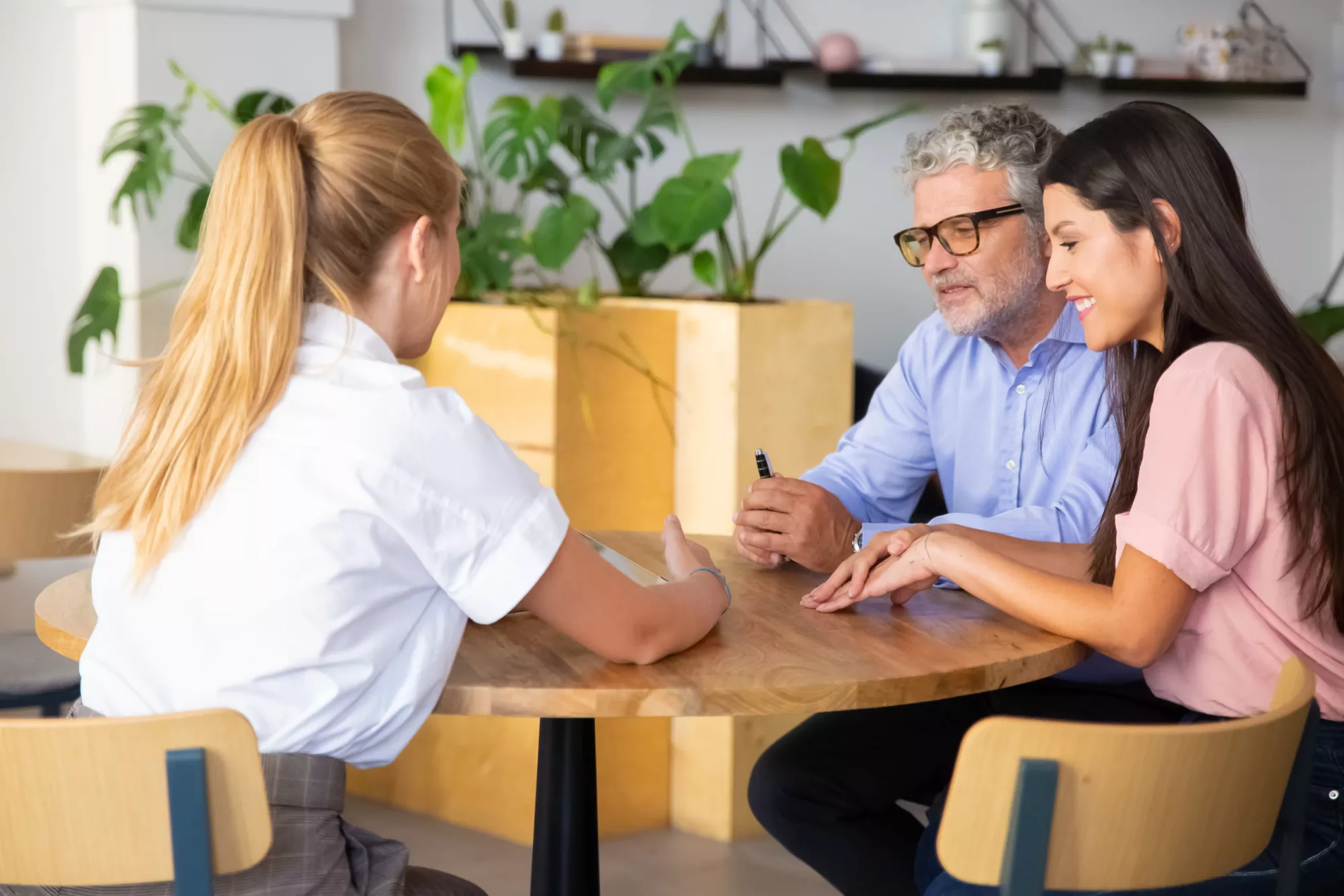 agent-feminin-presentant-du-contenu-tablette-quelques-clients-jeunes-matures-scaled.jpg