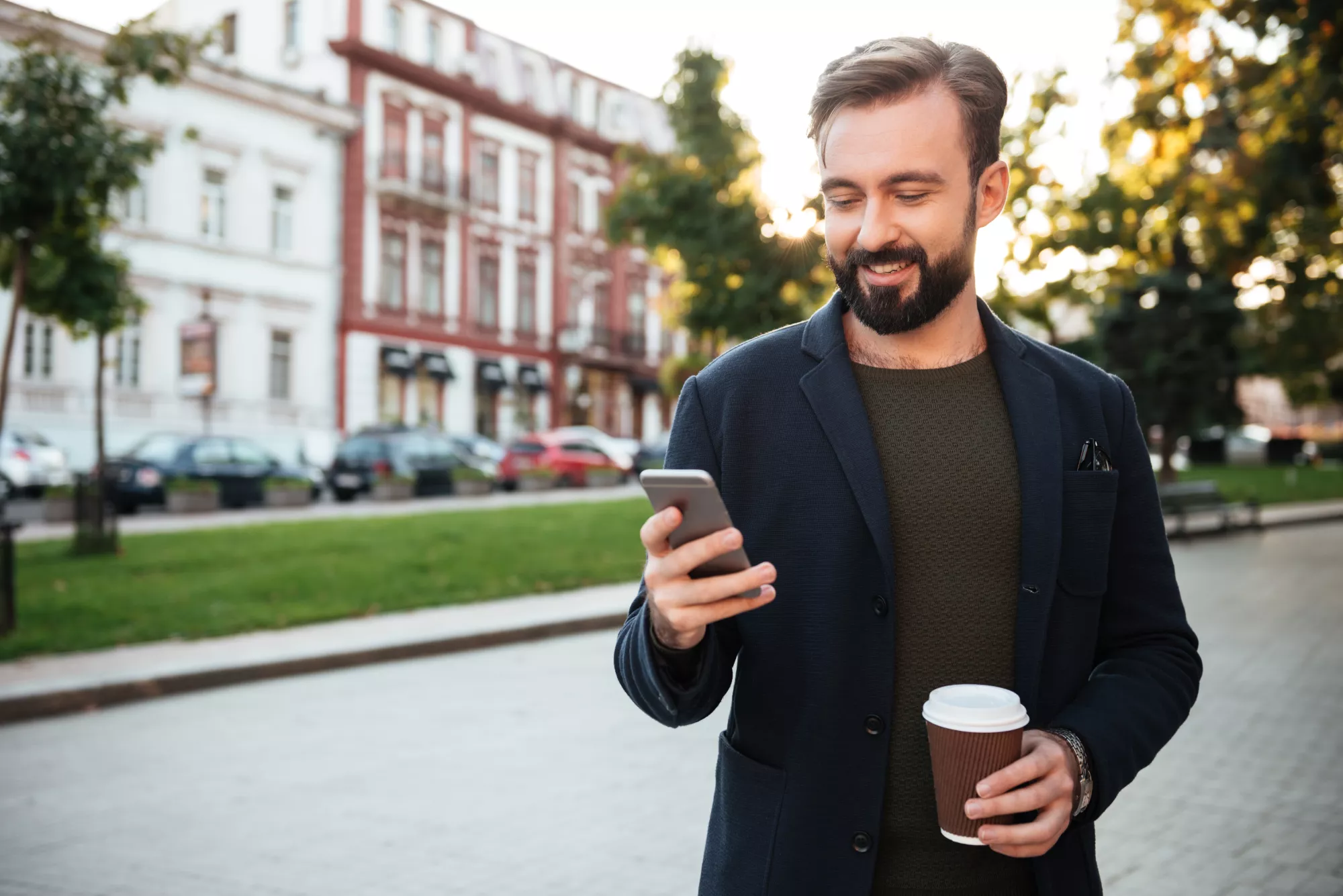 Homme marchant dans la rue un téléphone à la main